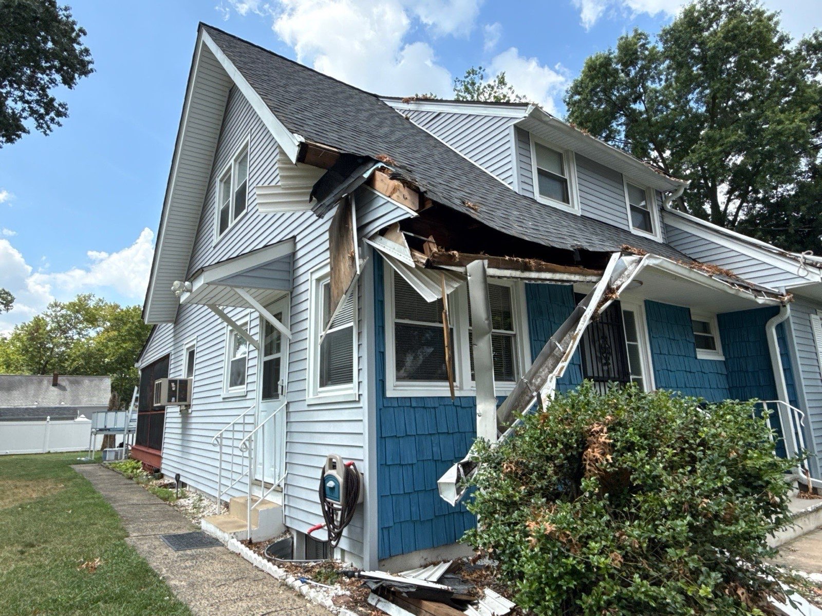 The damage documented: crushed front overhang, roofline and gutter
